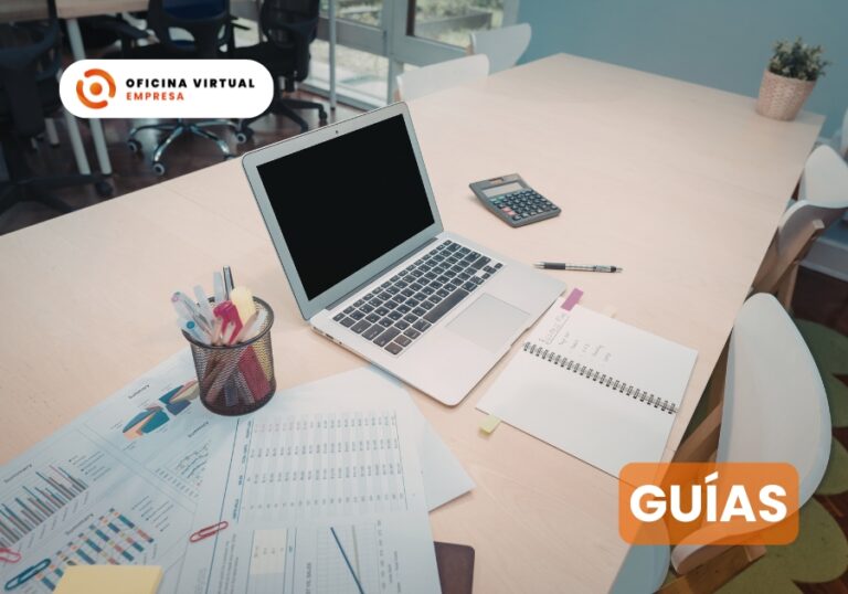 Portátil, calculadora y documentos sobre una mesa de oficina